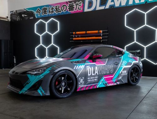 Finished sports car featuring a vibrant custom vinyl color-change wrap installed at a professional auto shop.