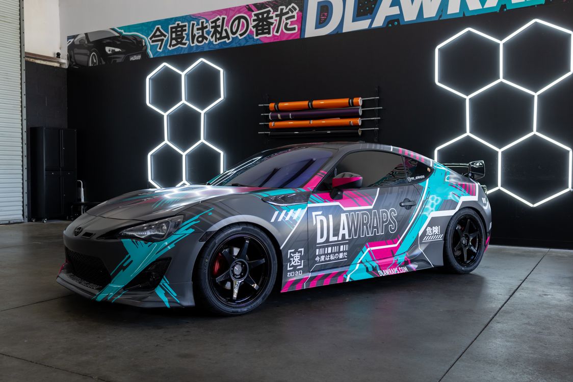 Finished sports car featuring a vibrant custom vinyl color-change wrap installed at a professional auto shop.