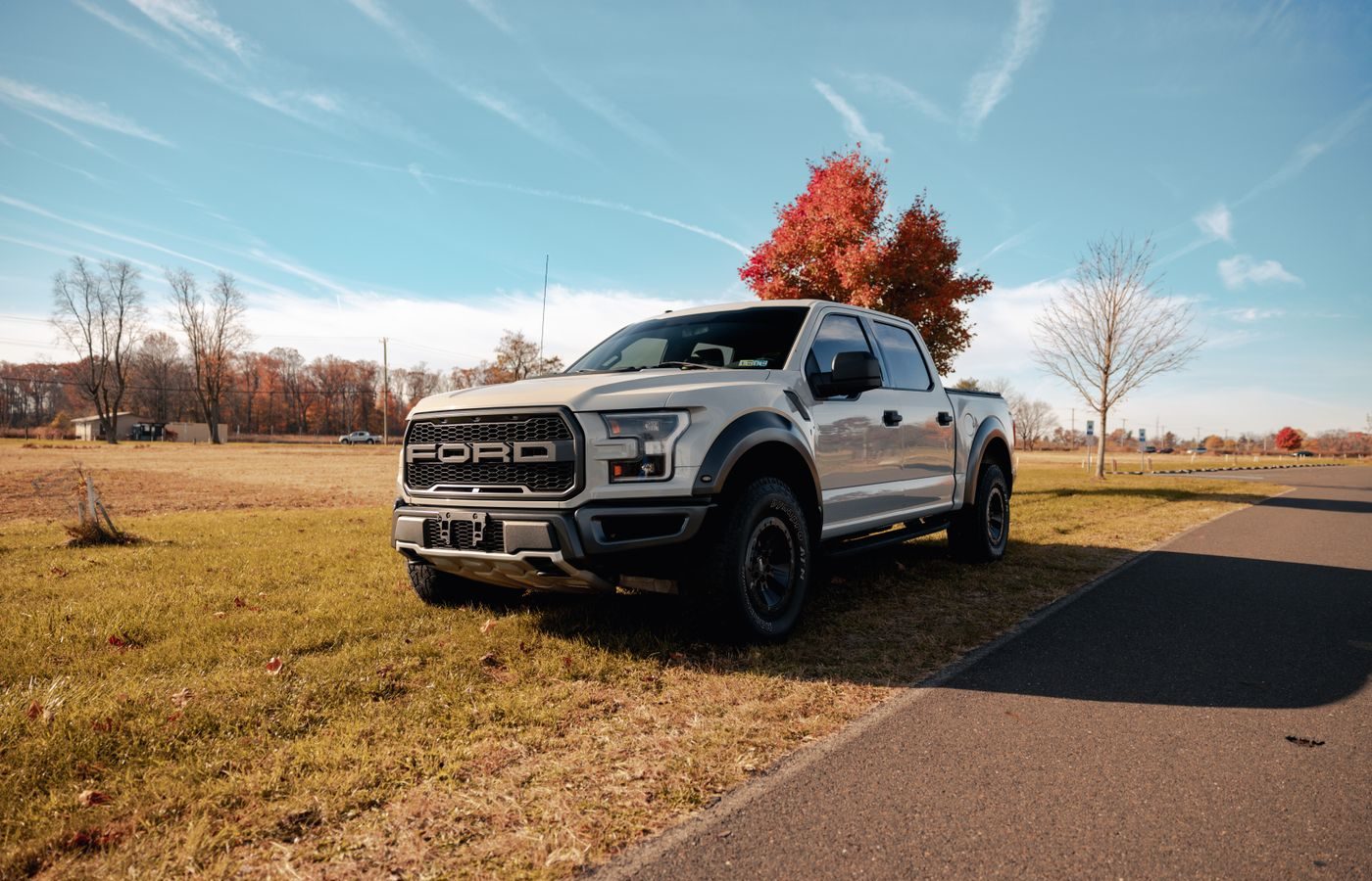 White Ford pickup truck parked on a green field, illustrating a full-size pickup wrap candidate