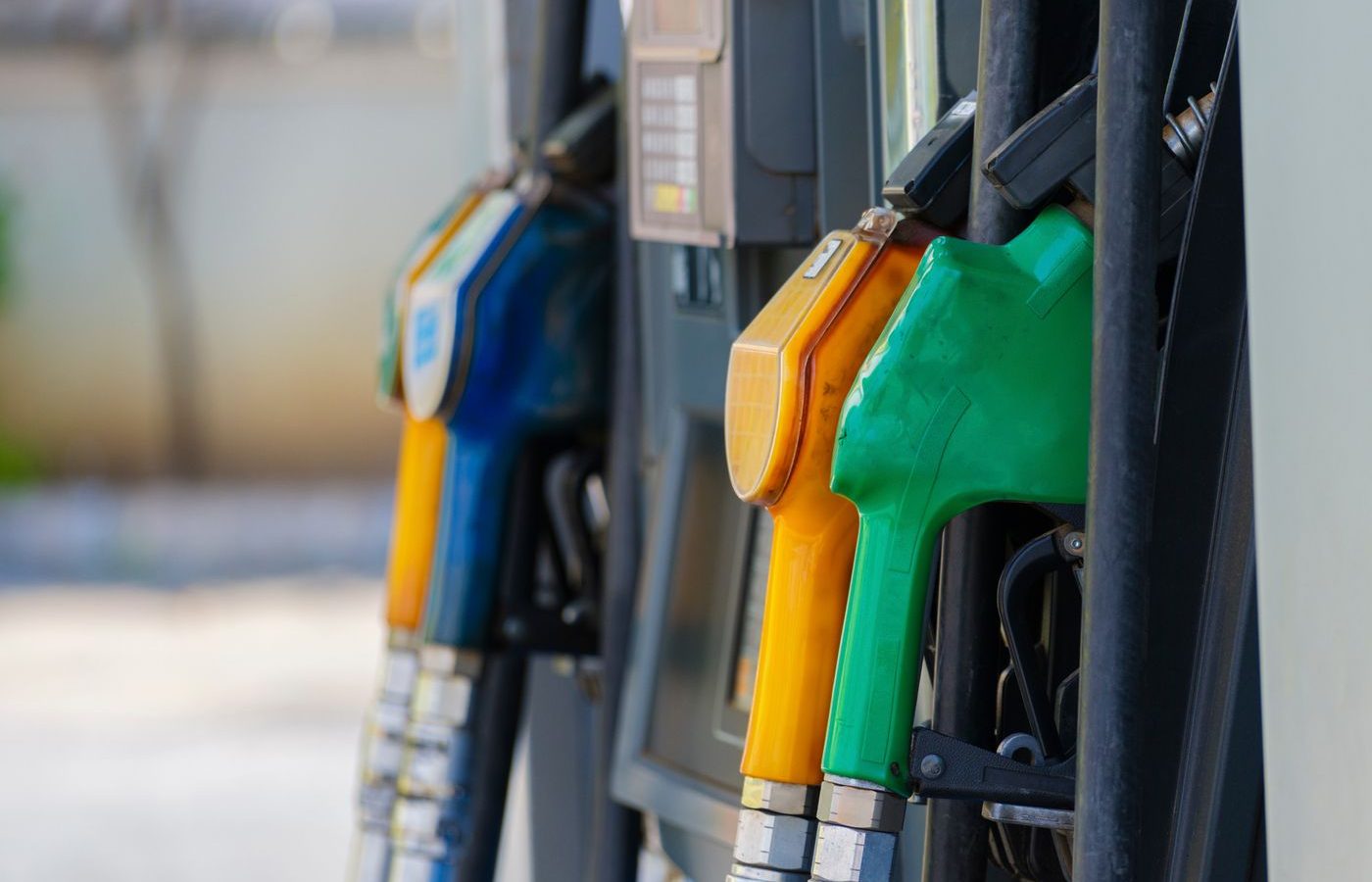 Close-up of colored fuel nozzles at a gas station showing different gasoline and diesel grades