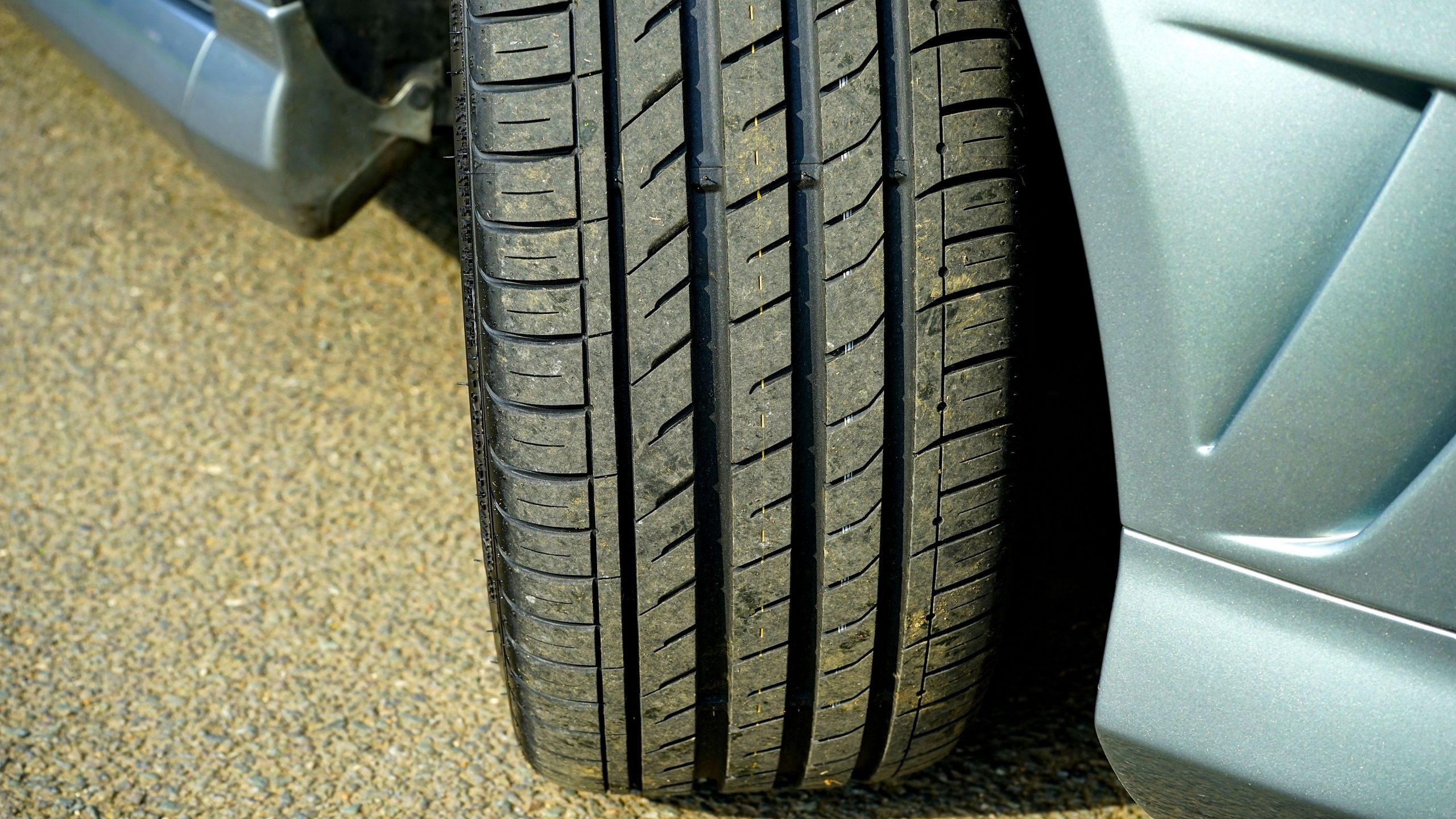 Close-up of a car tire on clean asphalt showing tread detail
