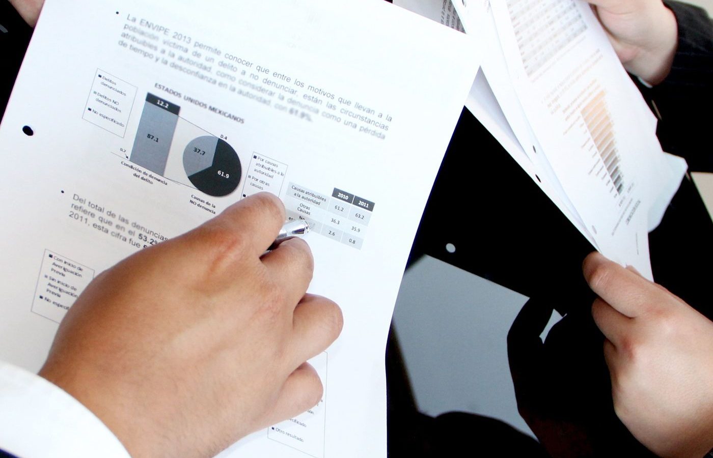 Person holding a stack of printed vehicle paperwork and documents