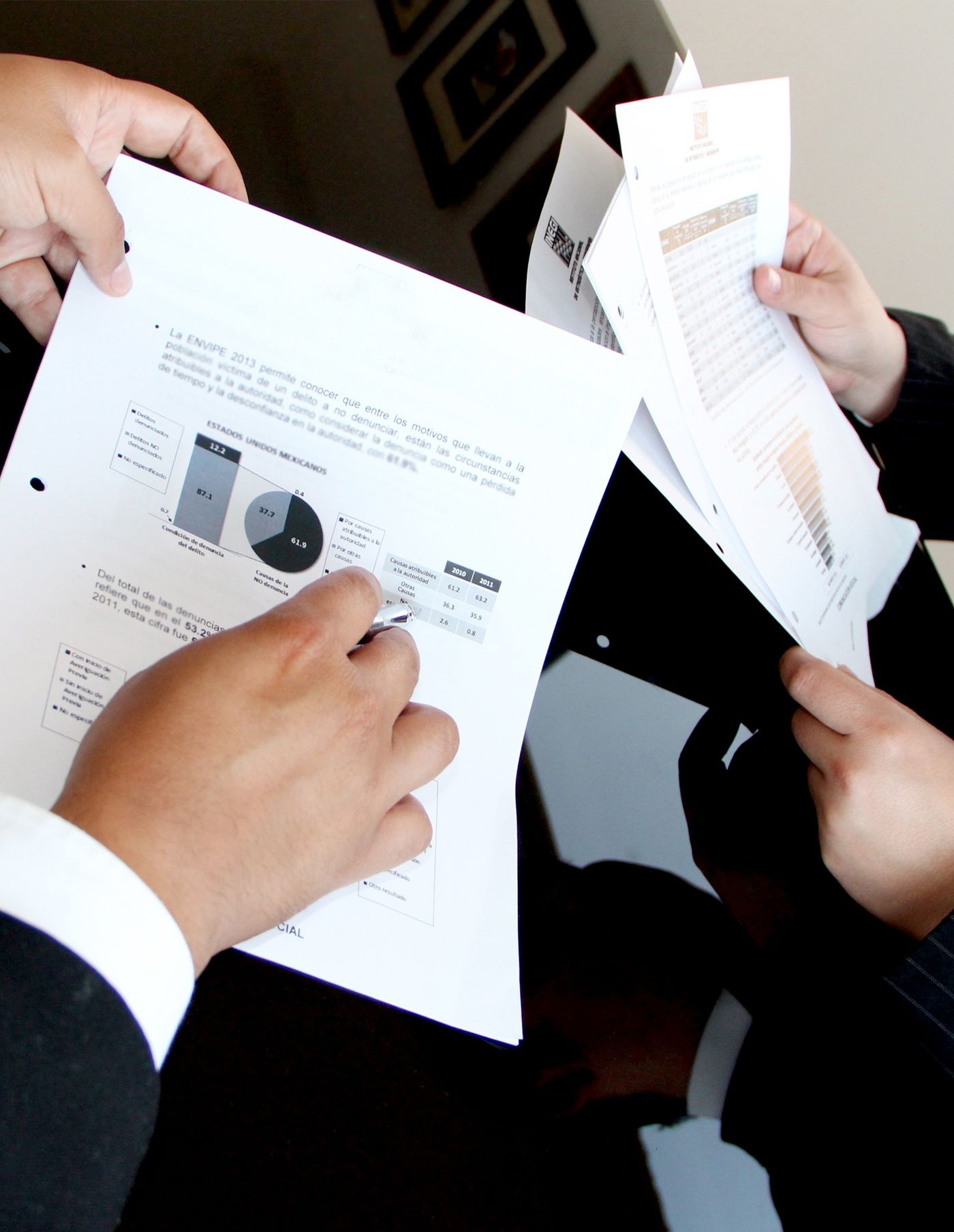 Person holding a stack of printed vehicle paperwork and documents