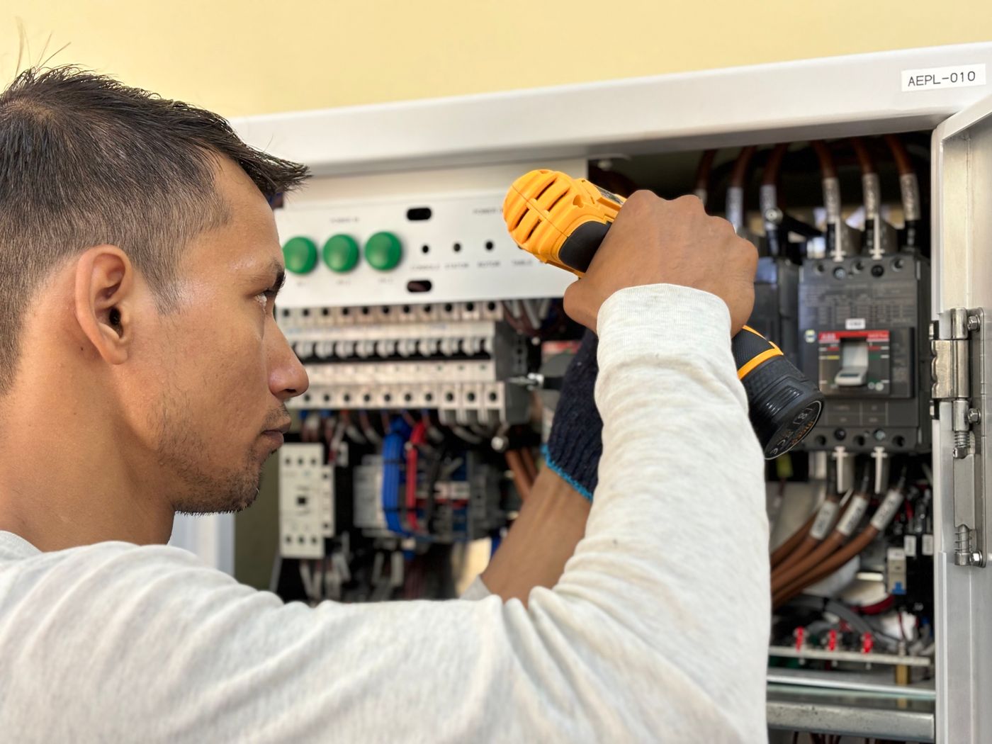 Electrician working on a home electrical panel, the kind of work needed before a Level 2 charger install