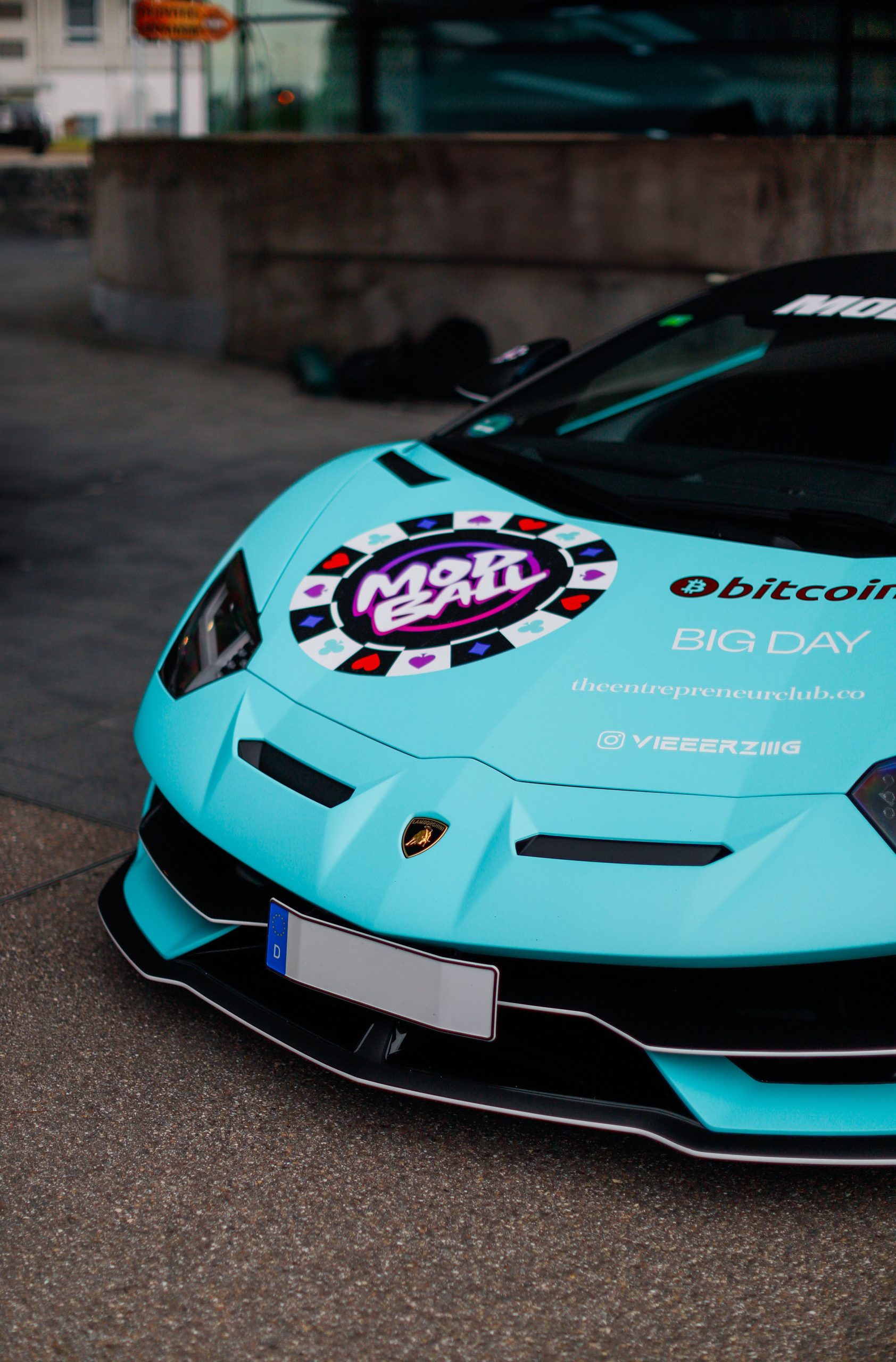 Close-up of a finished turquoise vinyl-wrapped sports car front end showing crisp panel edges