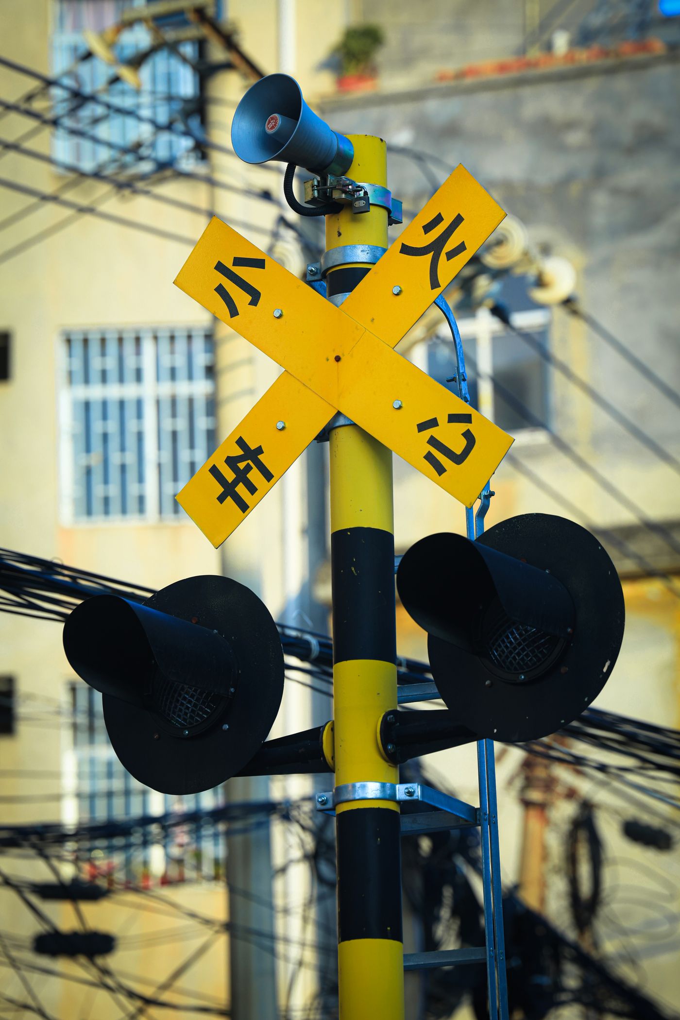 Railway crossing warning sign posted beside the tracks