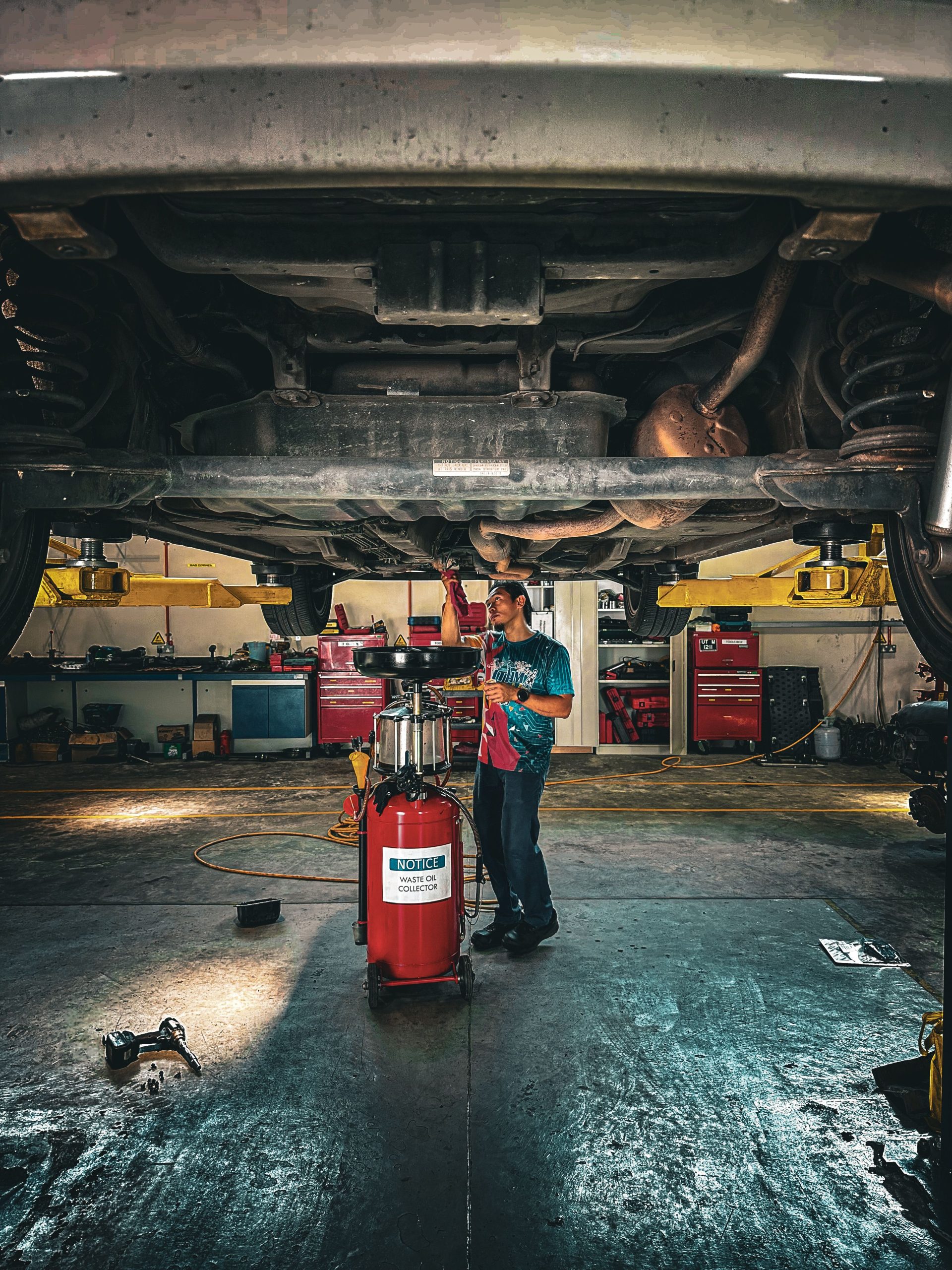 Mechanic working underneath a car in a repair shop
