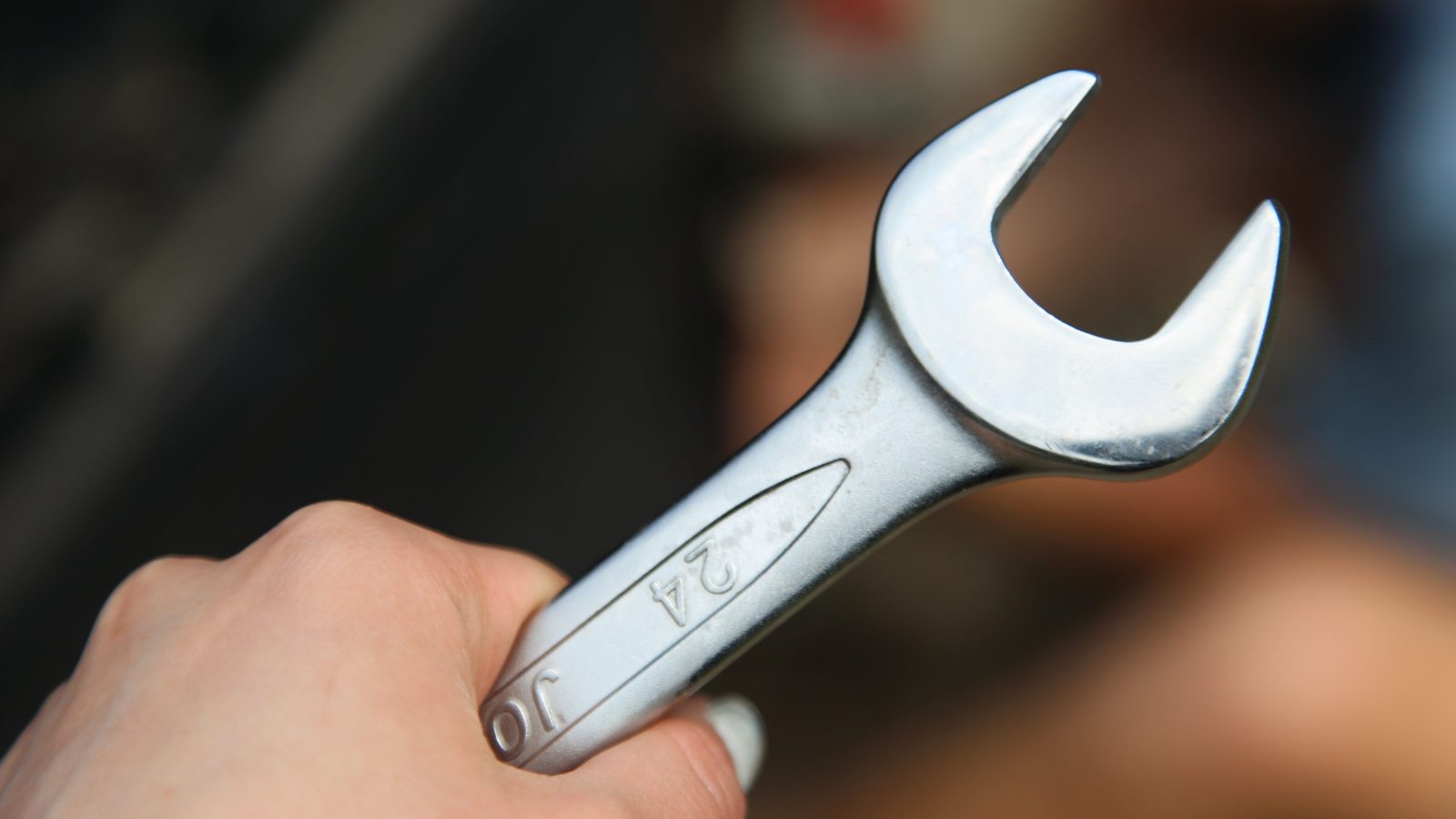 Close-up of a hand holding a metal wrench