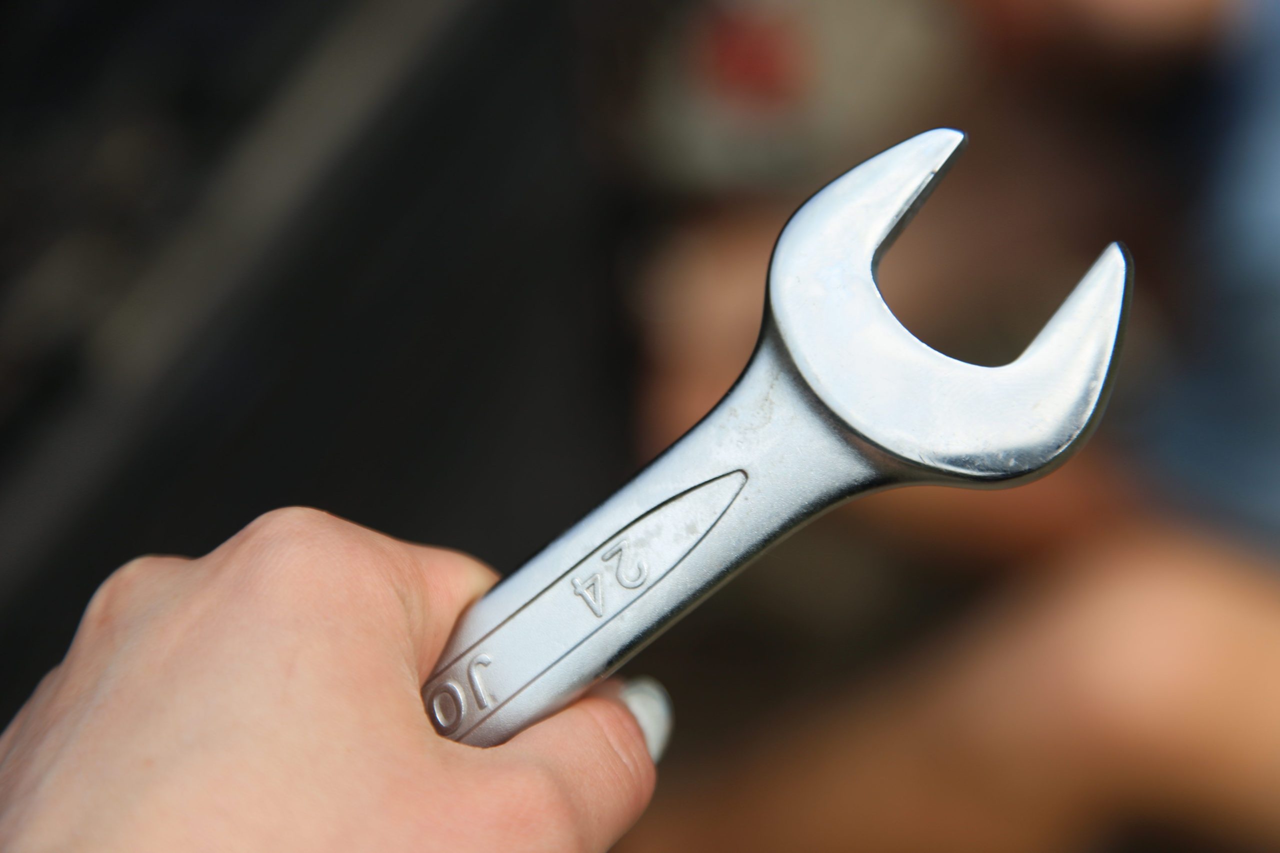 Close-up of a hand holding a metal wrench