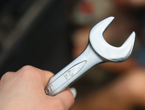 Close-up of a hand holding a metal wrench