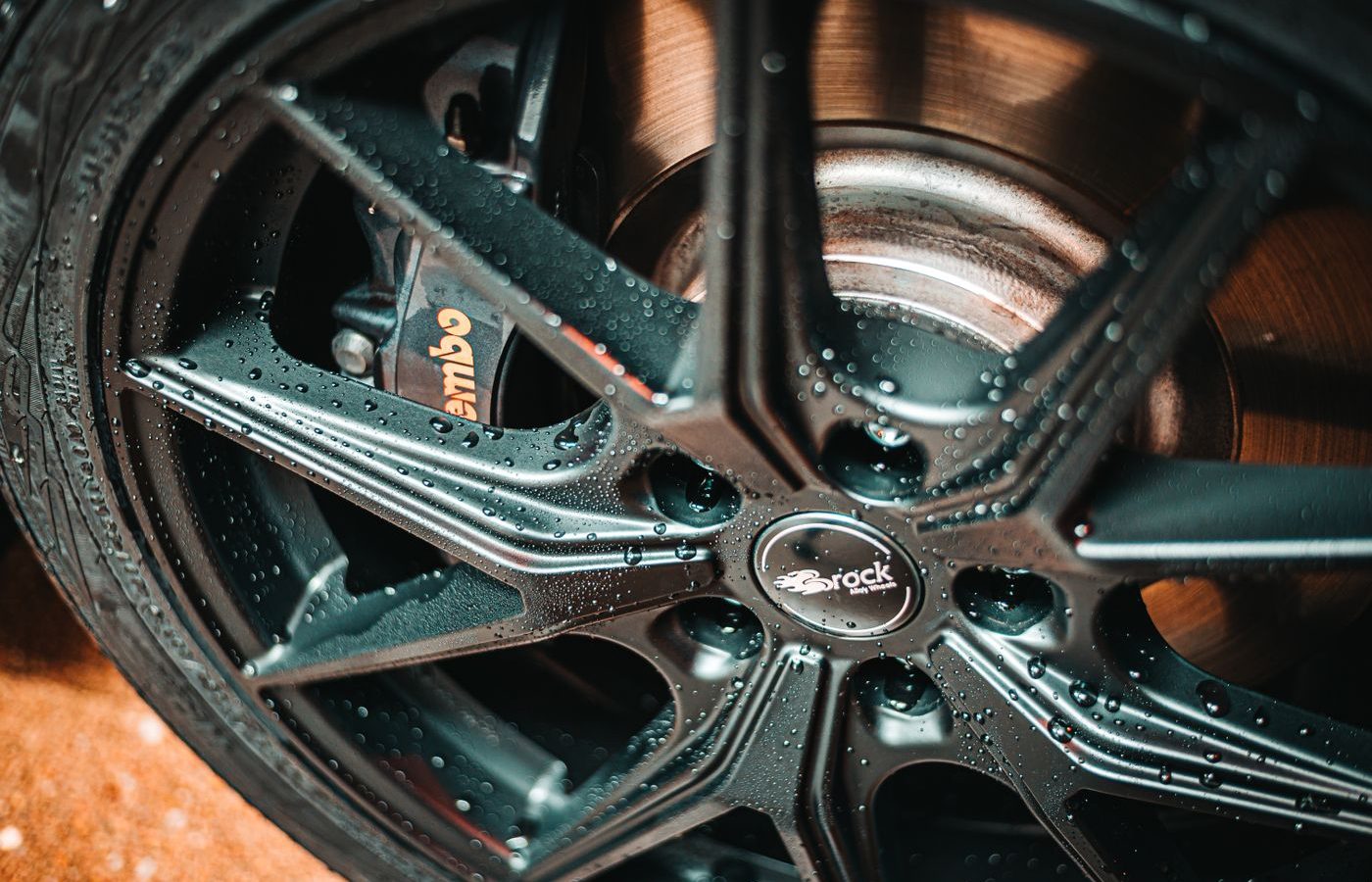 Close-up of an alloy wheel and tire, the visible end of one of a car's two axles
