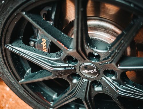 Close-up of an alloy wheel and tire, the visible end of one of a car's two axles