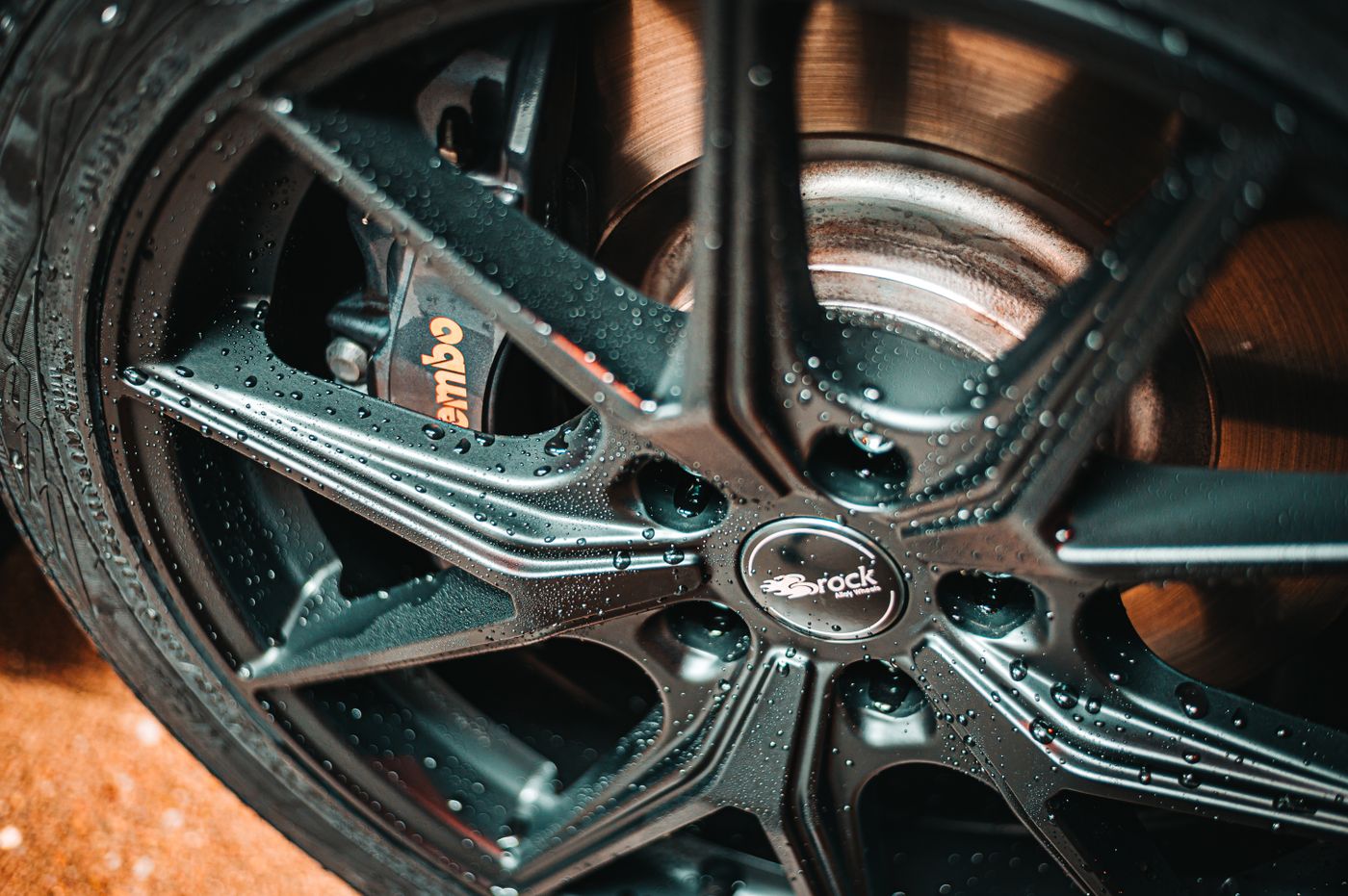 Close-up of an alloy wheel and tire, the visible end of one of a car's two axles