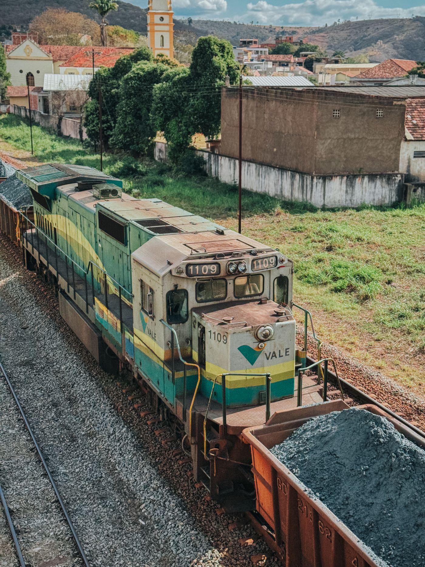 Colorful freight train passing through a rural town at a grade crossing