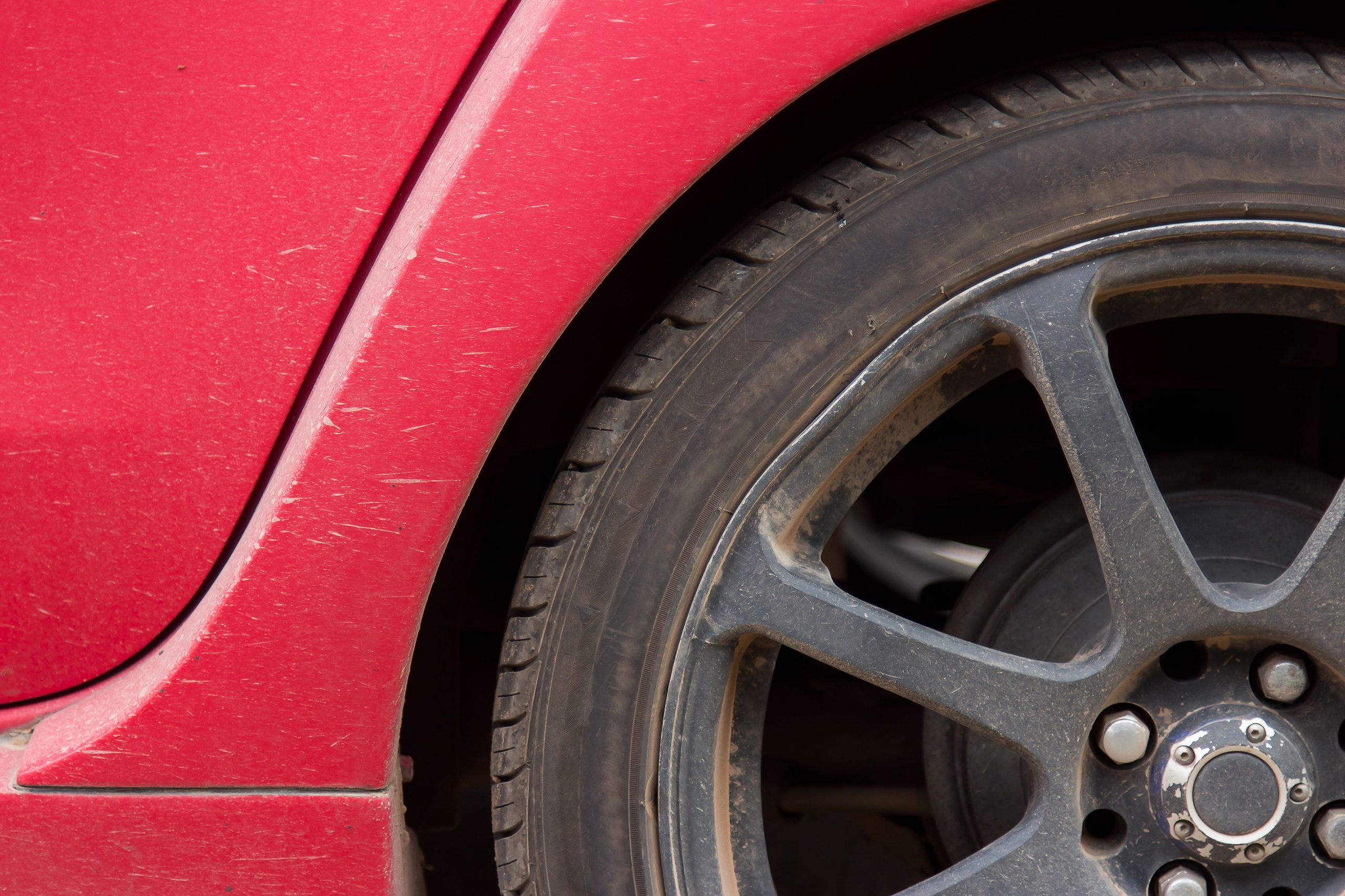 Close-up of a vehicle wheel and tire showing wear