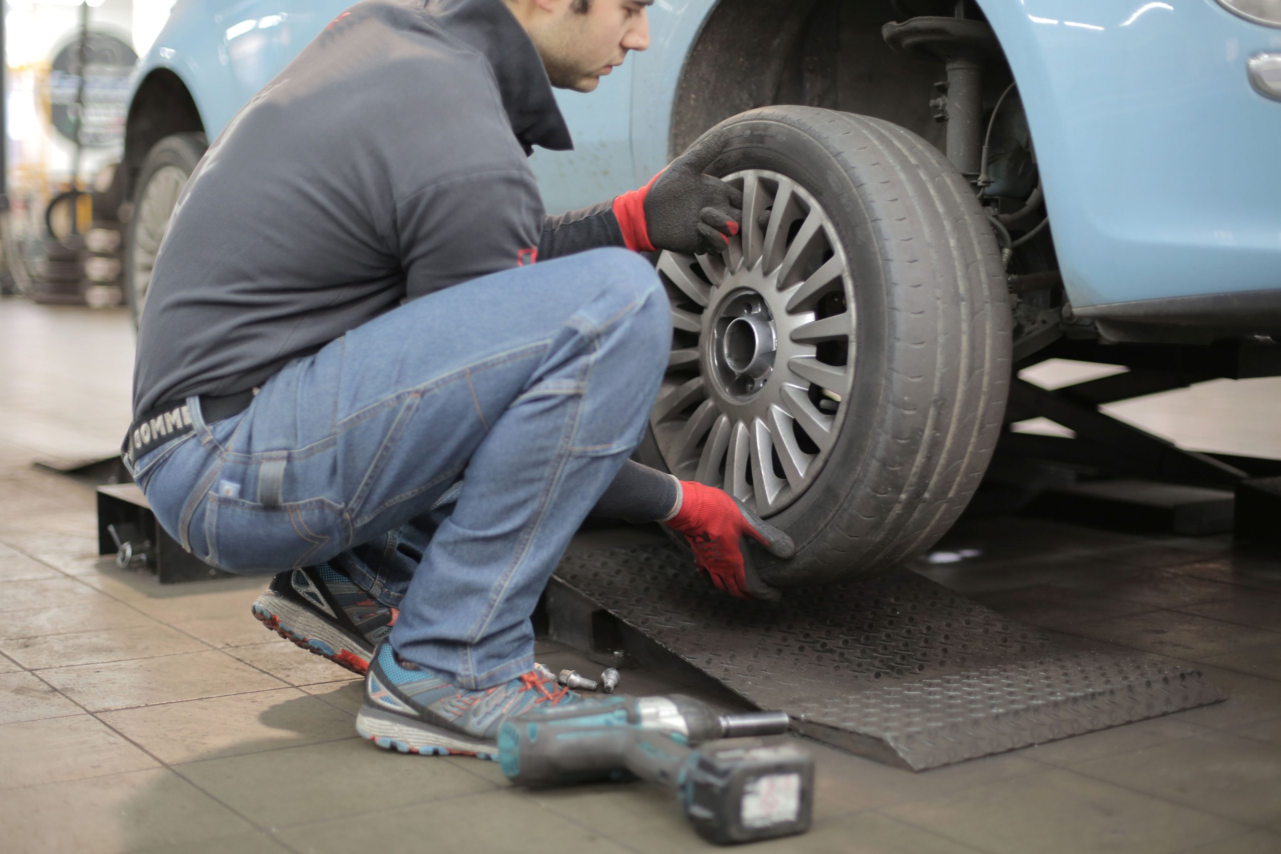 Mechanic inspecting a car engine on a lift