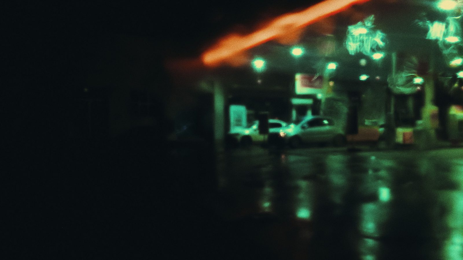 Cars parked on the street at night under streetlights