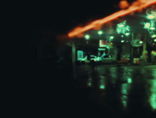 Cars parked on the street at night under streetlights