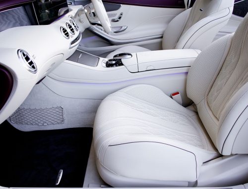 Car interior with clean white leather seats and dashboard, the source of new car smell
