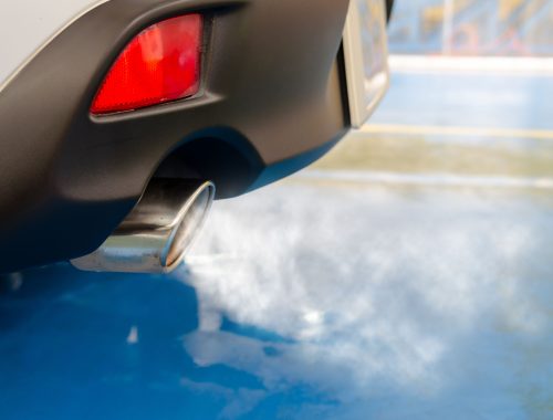 Close view of a car exhaust pipe emitting smoke