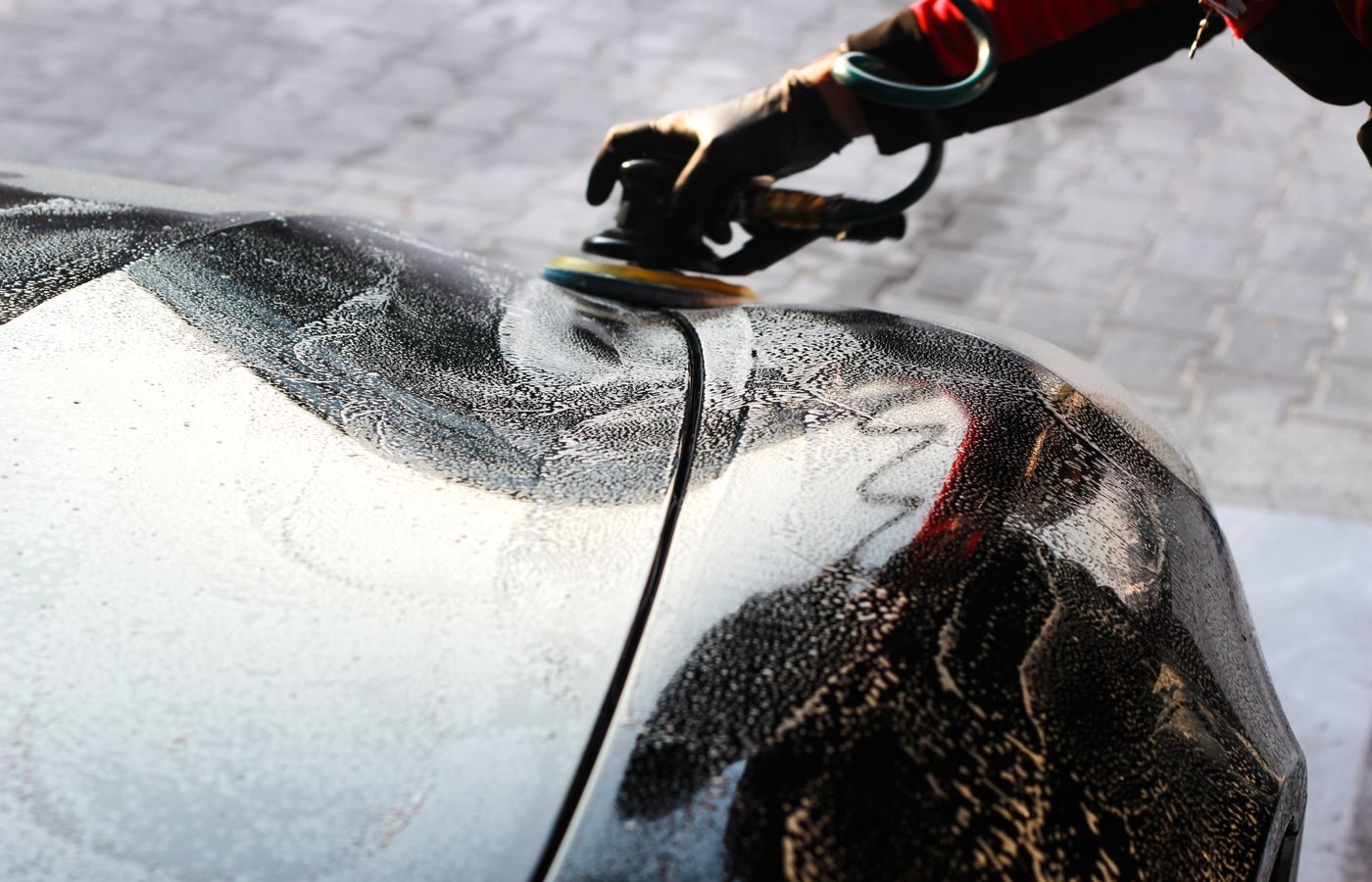 Close-up of a car being polished by hand during a wax application