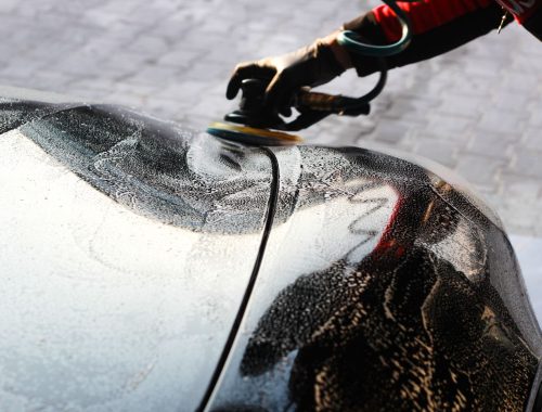 Close-up of a car being polished by hand during a wax application