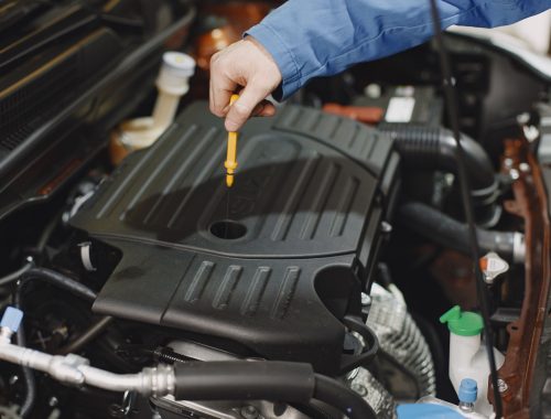 Person checking the oil of an engine with a dipstick