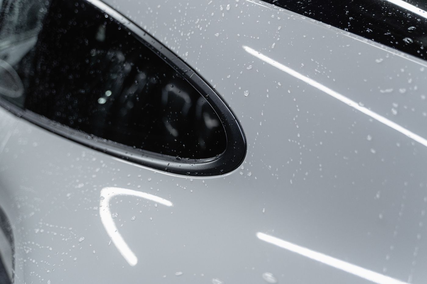 Tight water droplets beading on a white car's waxed paint surface