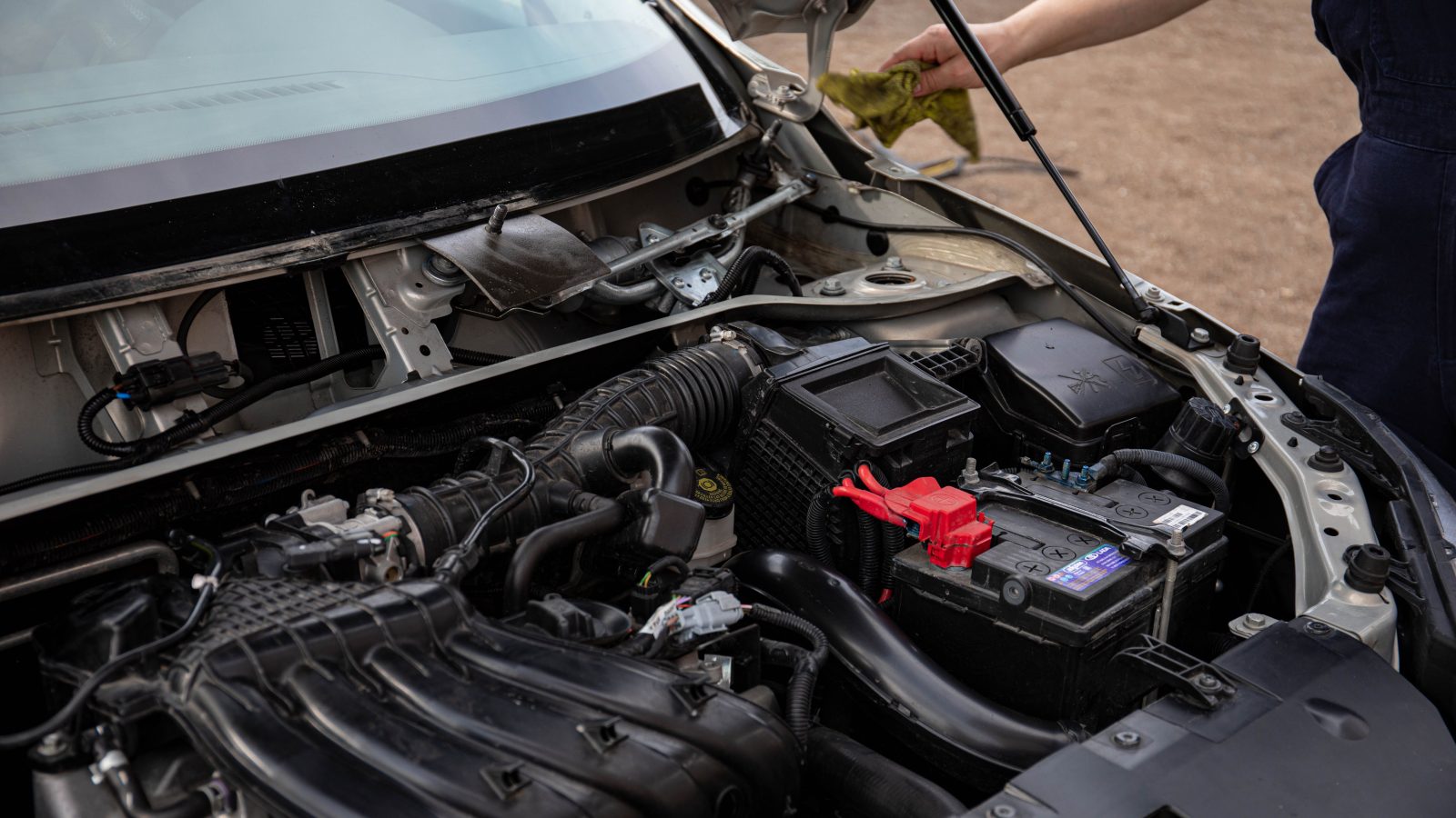 Mechanic inspecting the engine bay of a car with the hood open
