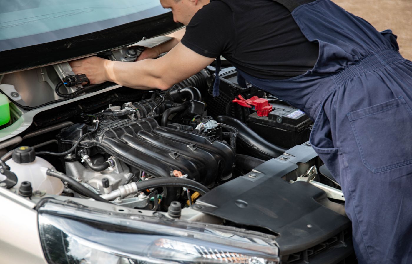 Mechanic working underneath a raised vehicle on suspension components
