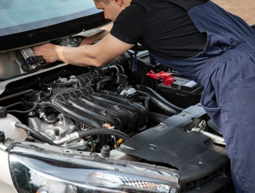 Mechanic working underneath a raised vehicle on suspension components