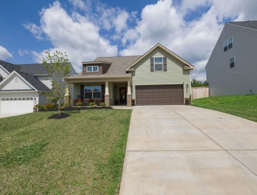 Modern suburban detached house with a wide driveway leading to an attached garage
