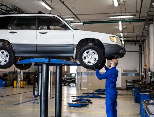 Mechanic inspecting a vehicle lifted in an auto repair shop