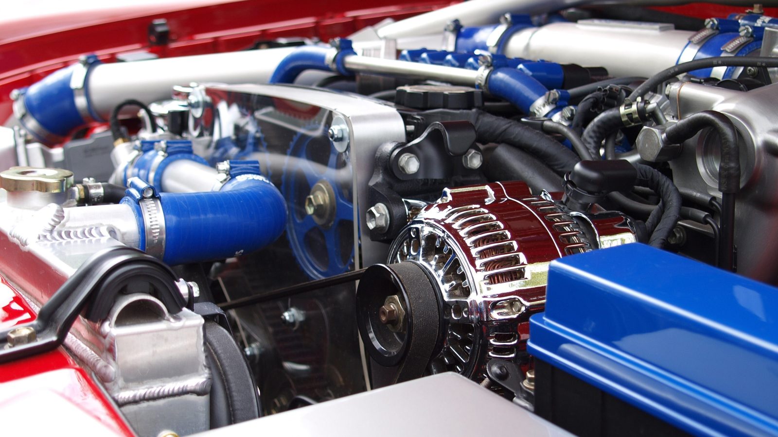 Close-up of a car engine bay showing the serpentine belt routed around several pulleys