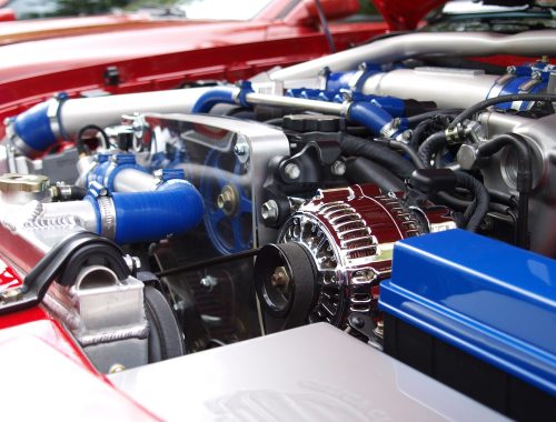 Close-up of a car engine bay showing the serpentine belt routed around several pulleys