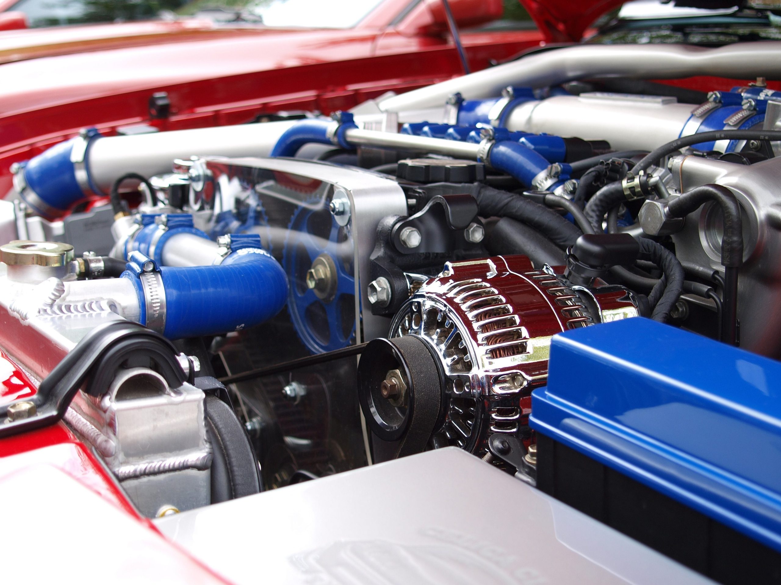 Close-up of a car engine bay showing the serpentine belt routed around several pulleys