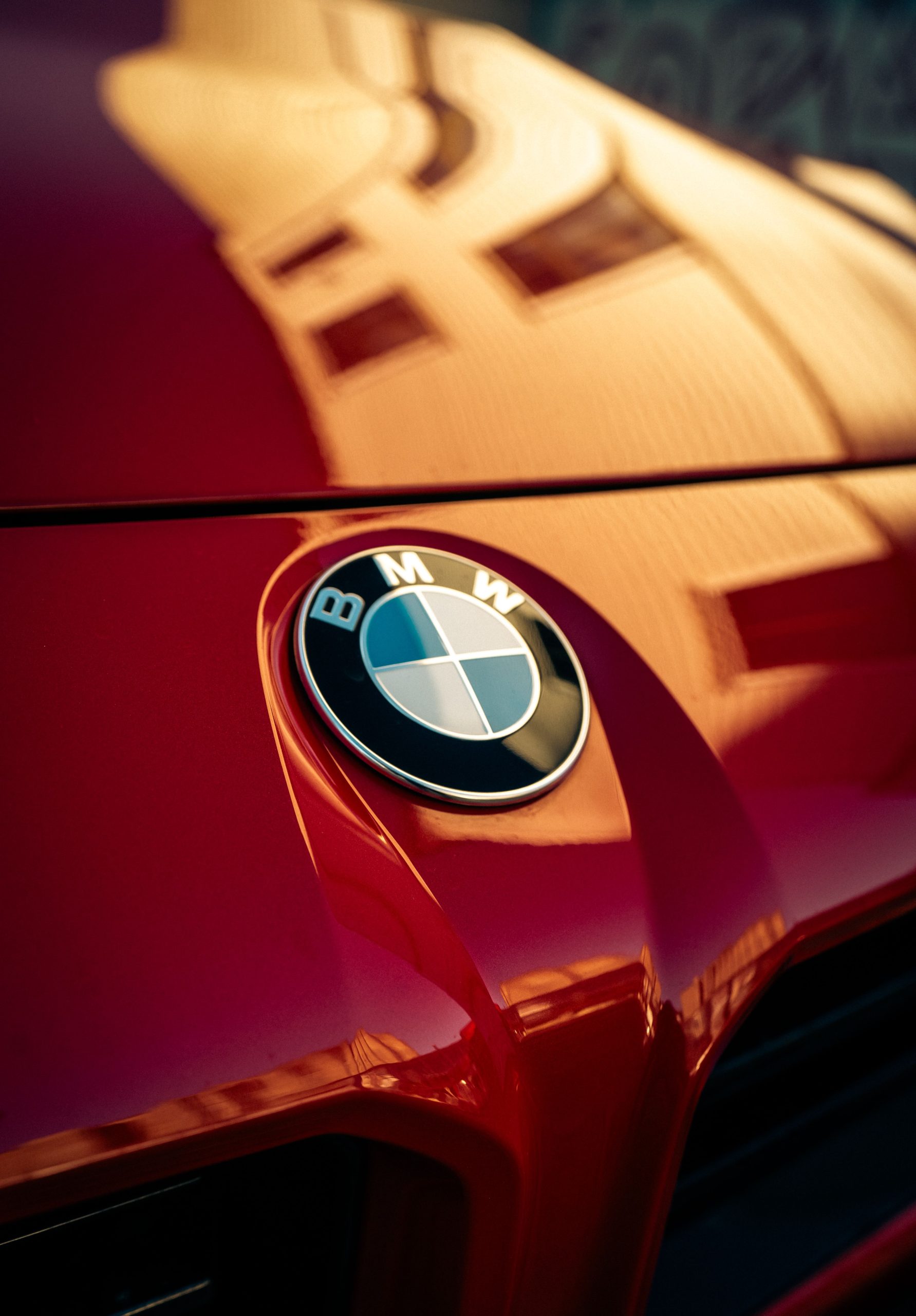 Close-up of a red car hood with glossy reflections